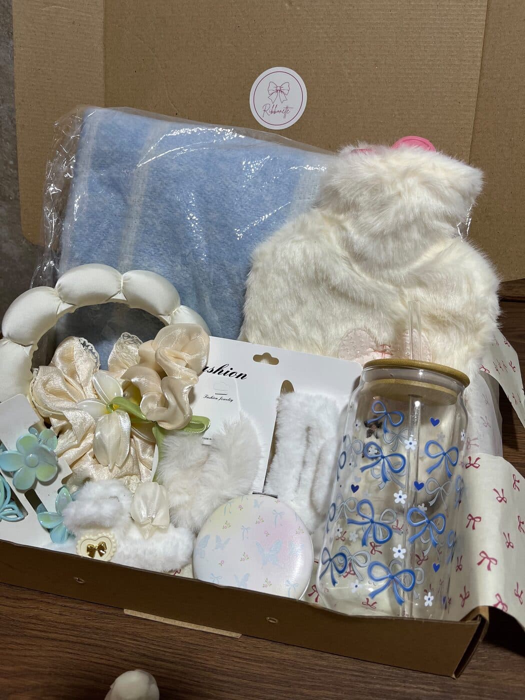 Ribbonette gift box with a blue blanket, faux-fur hot water bottle and bow glass cup