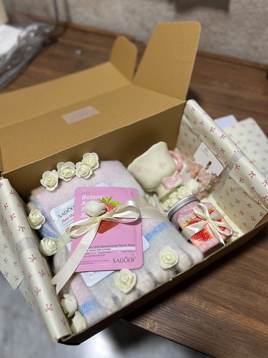 A Ribbonette gift box filled with roses, a soft throw, a candle and a pamper mask